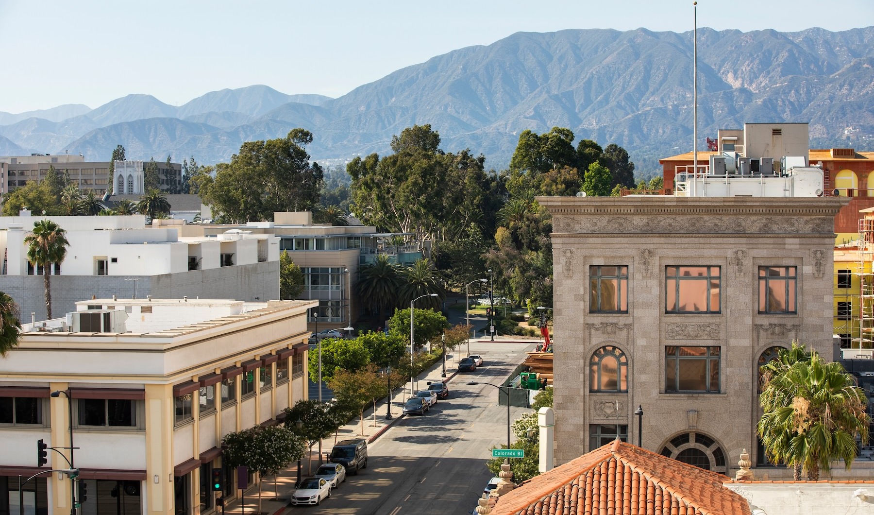 Close to the center of everything an aerial view of a downtown area with buildings trees and a view of mountains